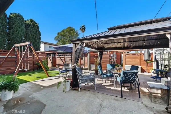 a view of a table and chairs in patio with a barbeque grill and plants