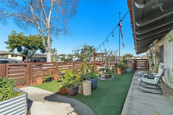 a view of a chair and table in backyard of the house