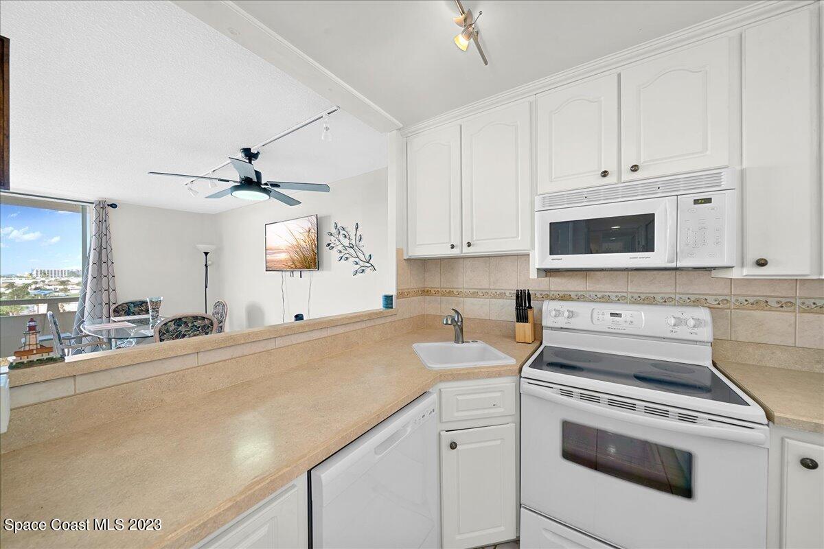 2020 North Atlantic Avenue, Unit 505 Cocoa Beach, FL 32931 - Photo 7 of 16 a kitchen with appliances a sink and cabinets