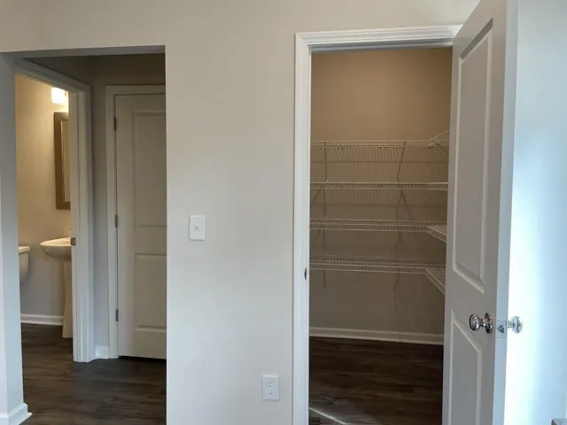 a view of walk in closet with wooden floor