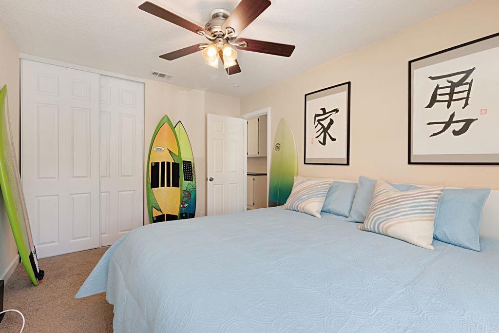 1917 Comanche Street Oceanside, CA 92056 - Photo 26 of 39 a bedroom with a bed and a chandelier