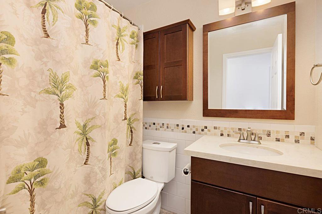 1917 Comanche Street Oceanside, CA 92056 - Photo 28 of 39 a bathroom with a sink a toilet and shower curtain