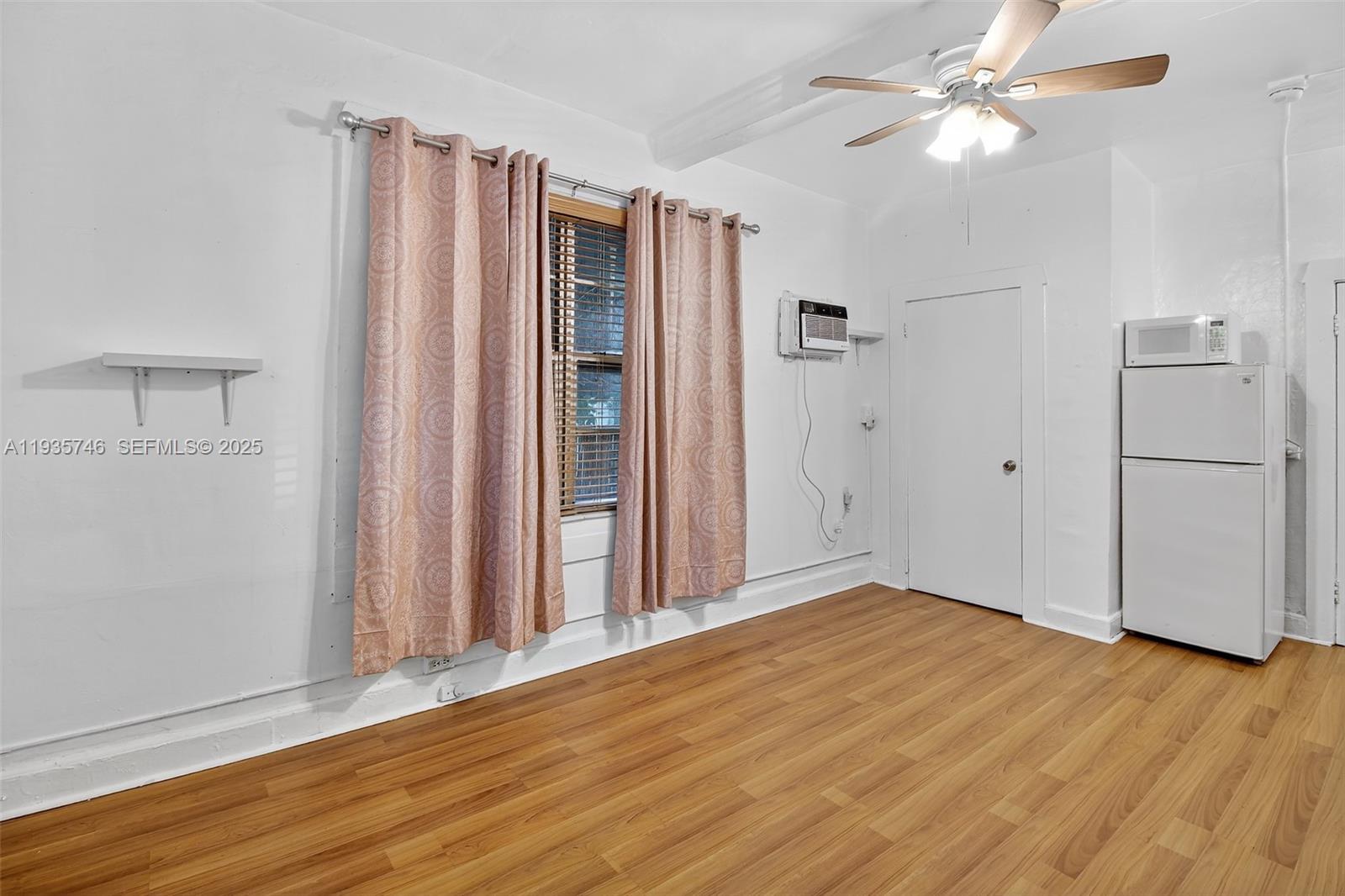 3409 South Le Jeune Road, Unit 5 Coral Gables, FL 33134 - Photo 5 of 14 wooden floor in an empty room with a window