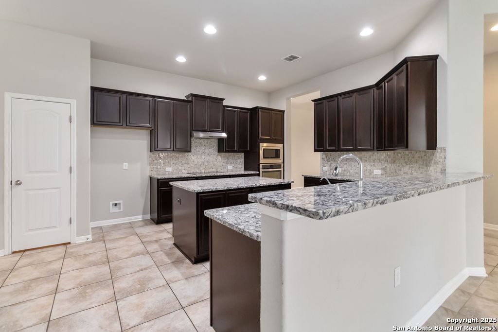 629 Cavan Cibolo, TX 78108 - Photo 3 of 20 a kitchen with stainless steel appliances granite countertop a sink and a stove