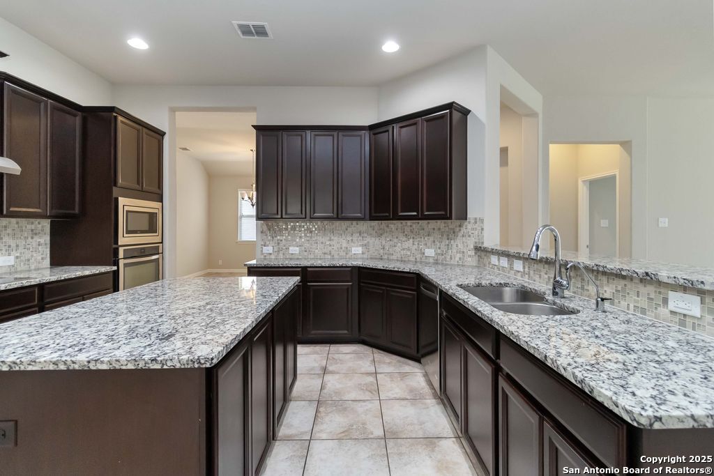 629 Cavan Cibolo, TX 78108 - Photo 4 of 20 a kitchen with stainless steel appliances granite countertop a sink stove and refrigerator