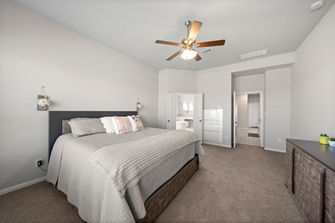 225 Peninsula Point Drive Montgomery, TX 77356 - Photo 12 of 38 a spacious bedroom with a bed and a chandelier