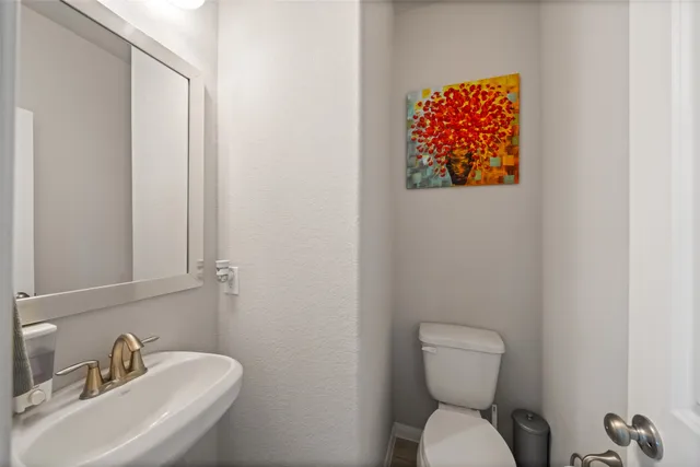 a bathroom with a toilet sink and mirror