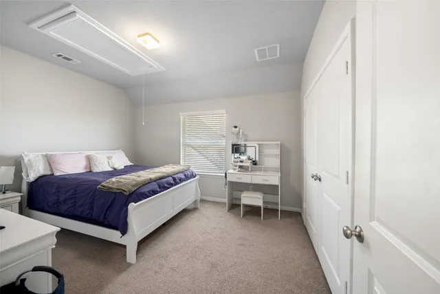a spacious bedroom with a bed and a cabinets