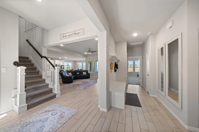 a view of a hallway with wooden floor and staircase
