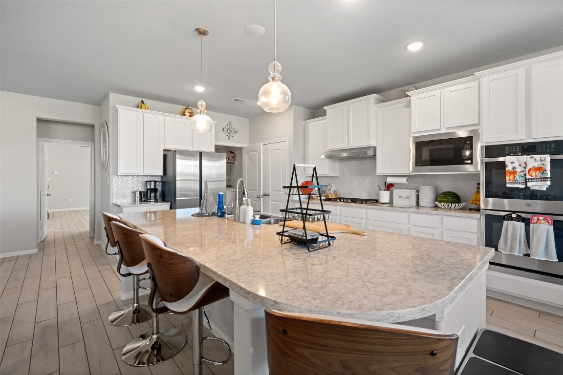 225 Peninsula Point Drive Montgomery, TX 77356 - Photo 7 of 38 a kitchen with kitchen island granite countertop a sink a center island stainless steel appliances and cabinets