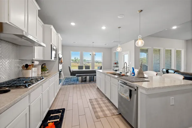 a kitchen with counter top space a sink appliances and cabinets