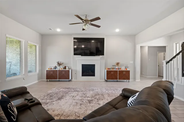 a living room with furniture a flat screen tv and a fireplace