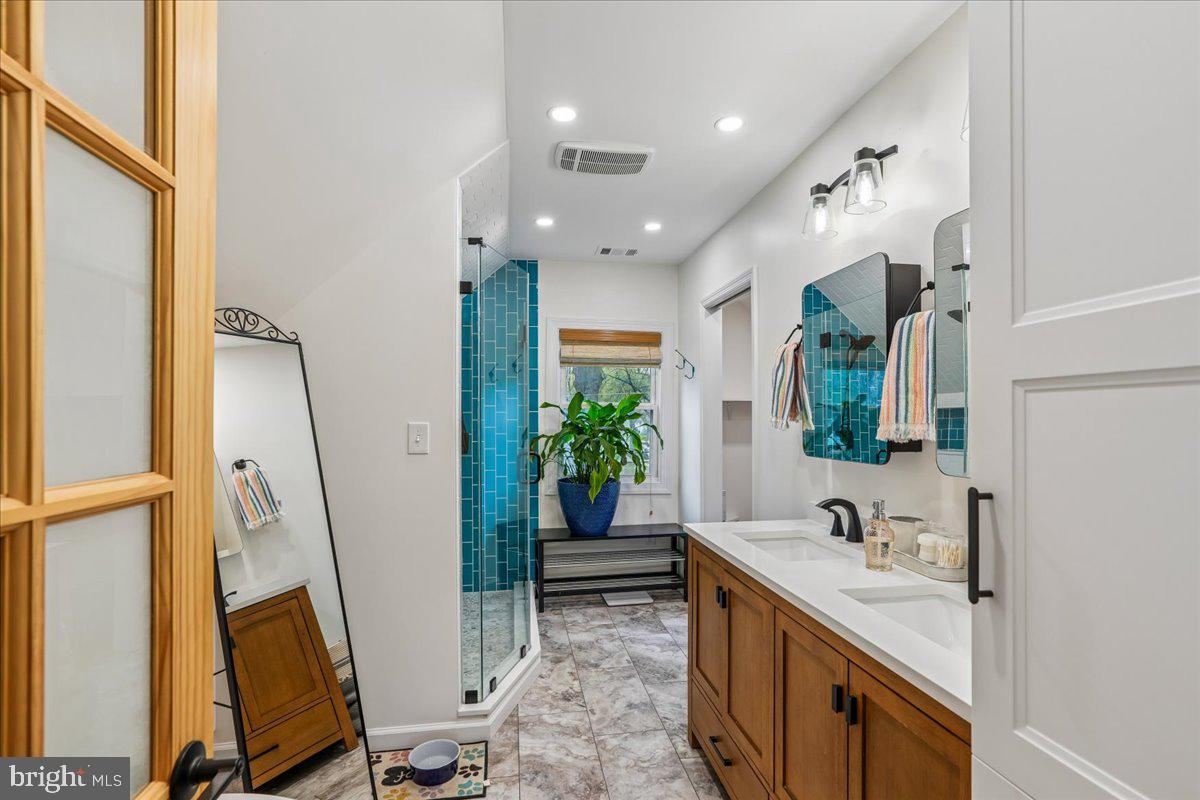 4801 Nicholson Street Riverdale, MD 20737 - Photo 24 of 39 a spacious bathroom with a sink a mirror and a shower