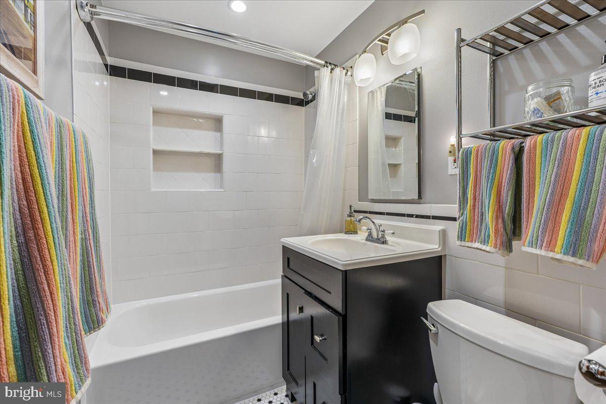 4801 Nicholson Street Riverdale, MD 20737 - Photo 32 of 39 a bathroom with a sink a toilet a mirror and a shower