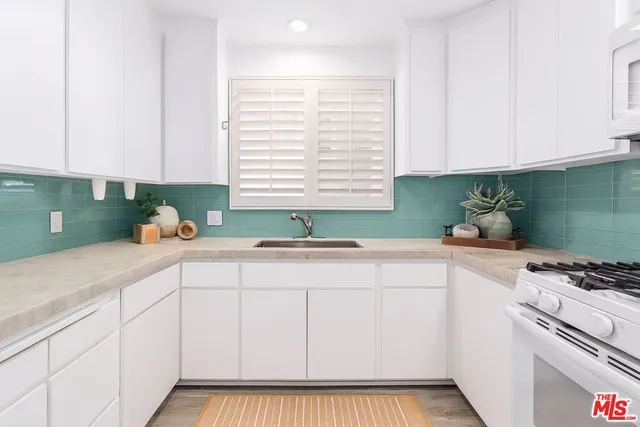 a kitchen with granite countertop white cabinets and white appliances