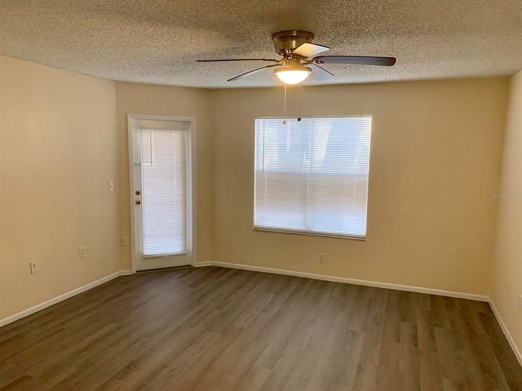 5263 Images Circle, Unit 106 Kissimmee, FL 34746 - Photo 2 of 17 a view of an empty room with wooden floor and a window
