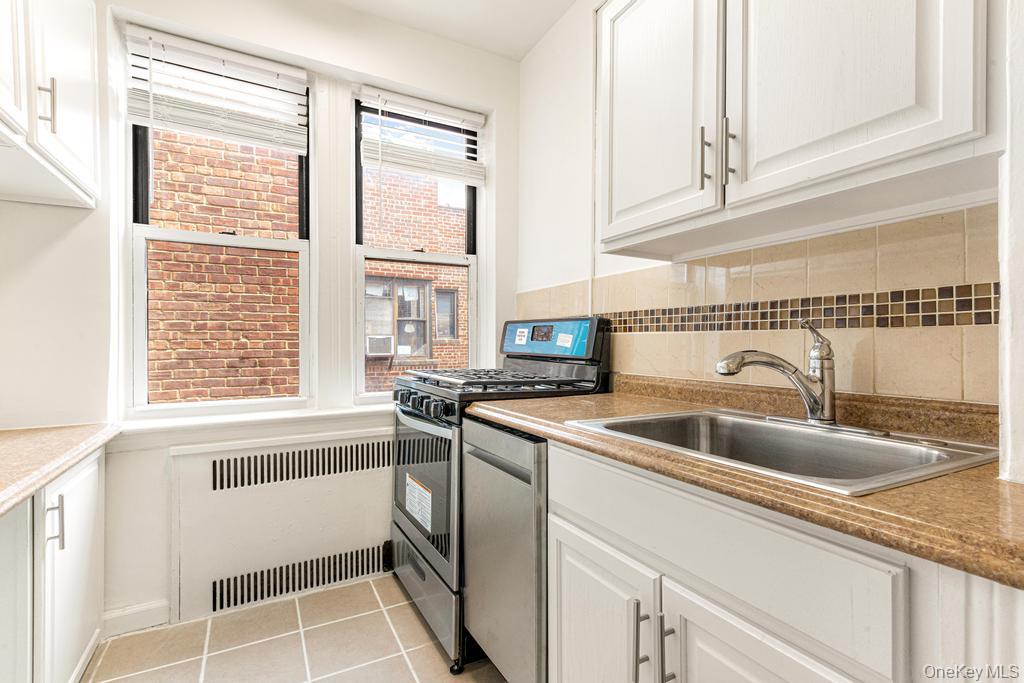 100-10 67th Road, Unit 6L Queens, NY 11375 - Photo 8 of 26 a kitchen with granite countertop a sink and a window