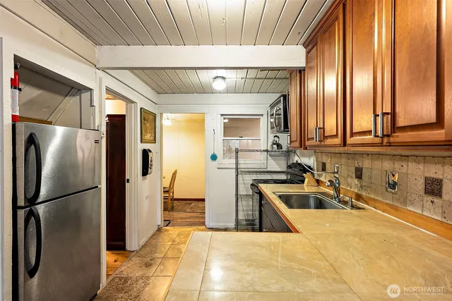 a view of a kitchen with stainless steel appliances granite countertop a refrigerator and a sink