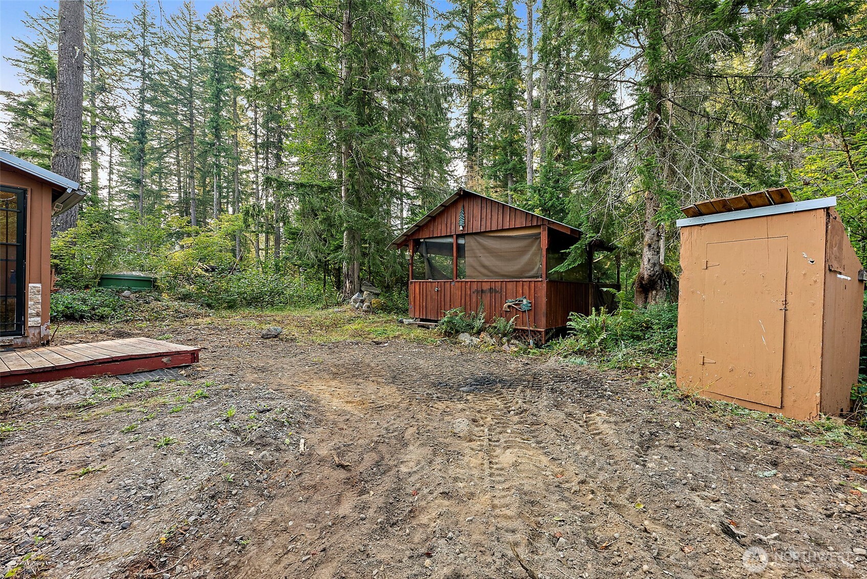 270 Skate Creek Road North Ashford, WA 98304 - Photo 26 of 36 a view of a wooden house with large trees and wooden fence