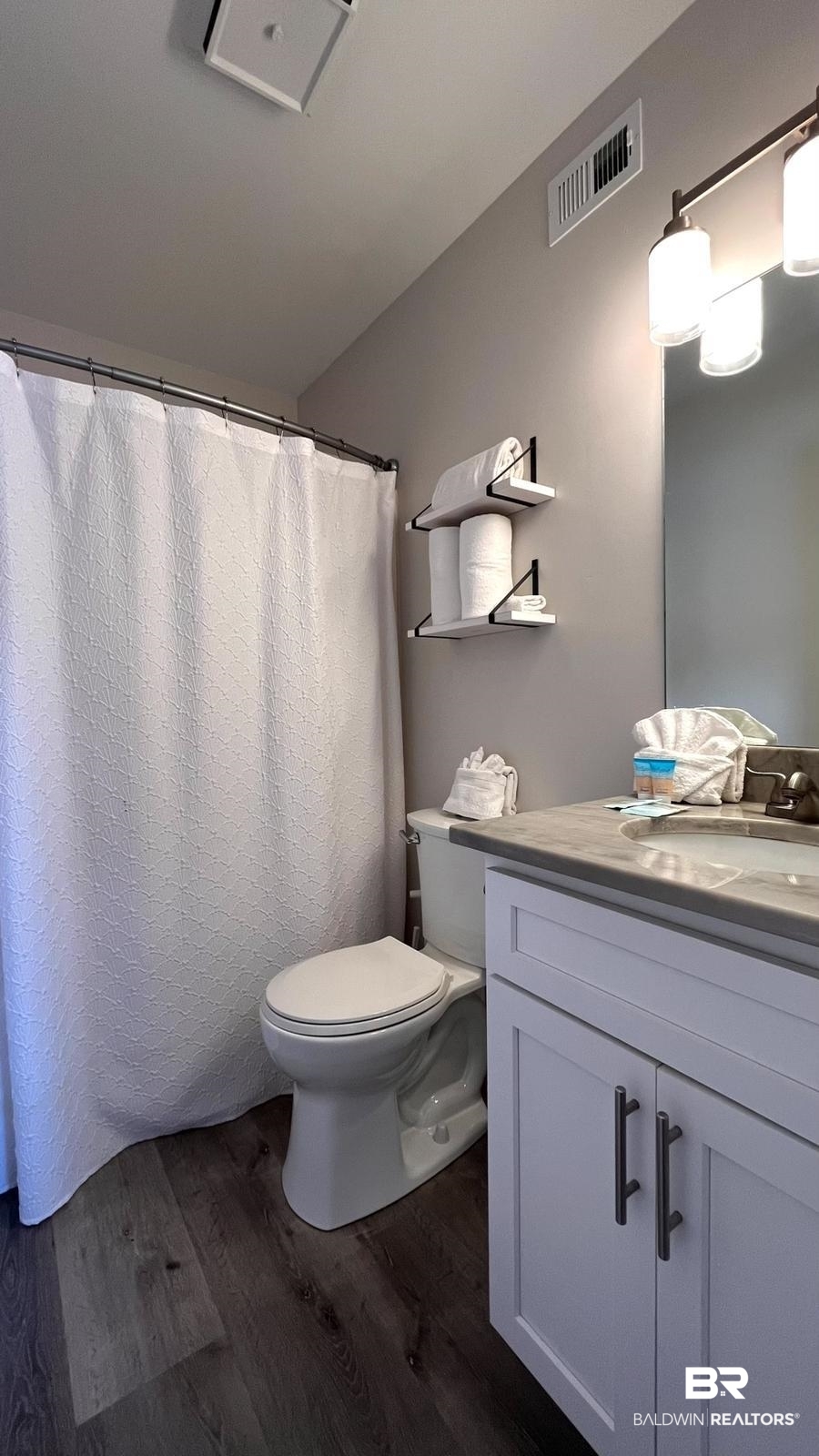 25861 Canal Road, Unit 75 Orange Beach, AL 36561 - Photo 16 of 40 Bathroom with toilet, hardwood / wood-style floors, and vanity