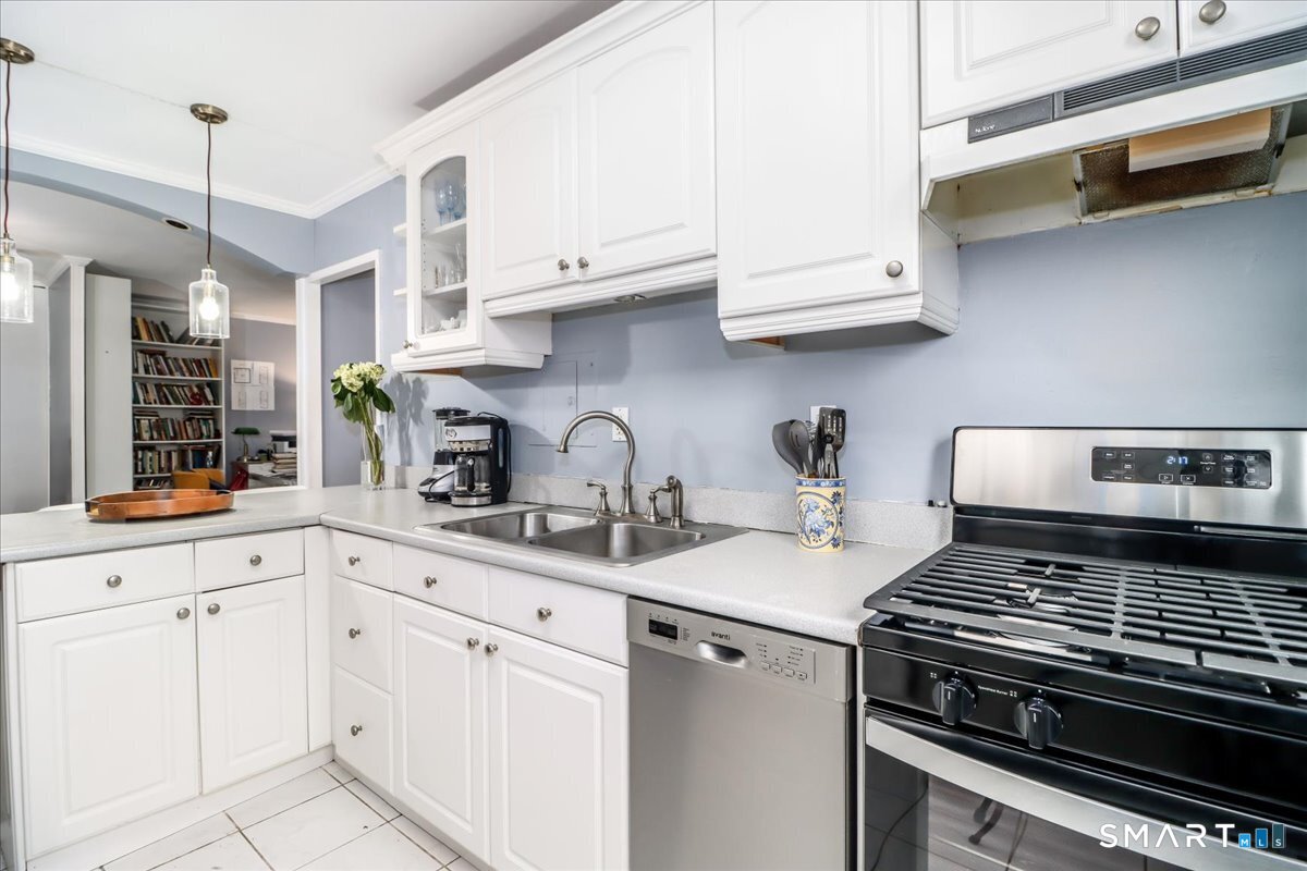 30 Glenbrook Road, Unit 10F Stamford, CT 06902 - Photo 12 of 30 a kitchen with white cabinets and appliances