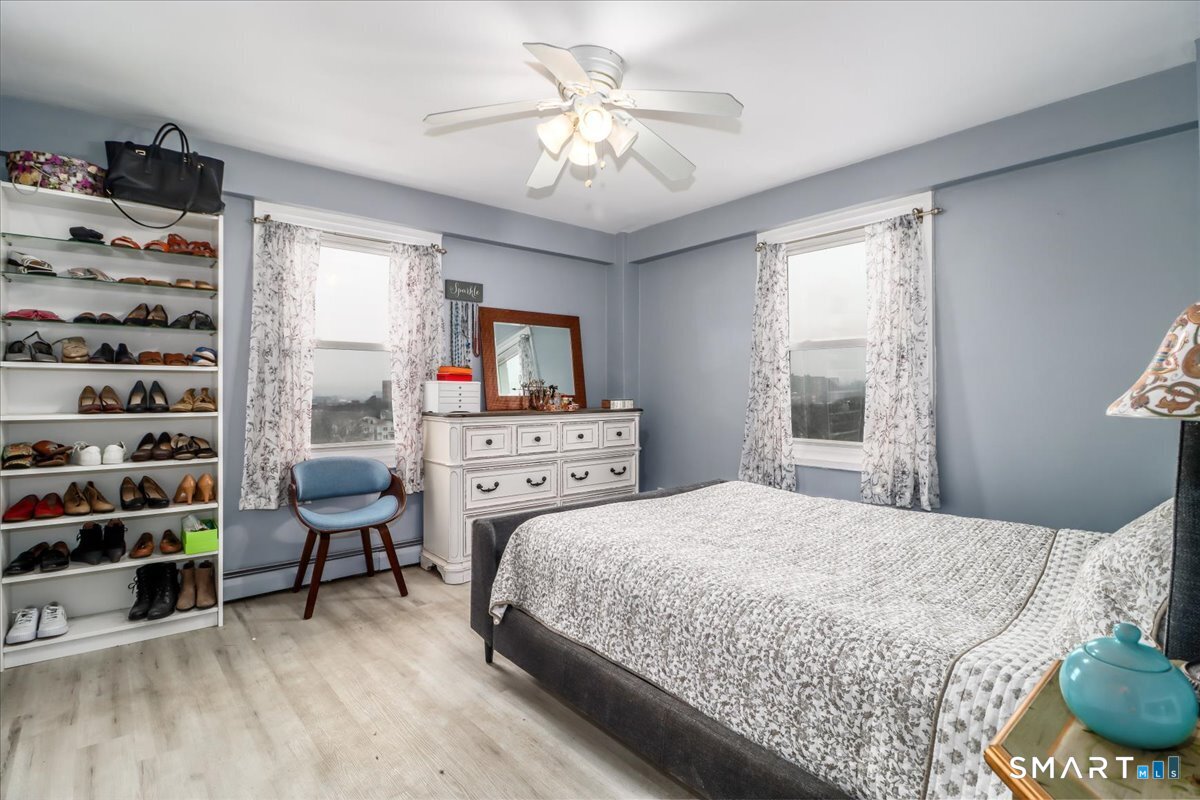 30 Glenbrook Road, Unit 10F Stamford, CT 06902 - Photo 14 of 30 a bedroom with a bed a chair and a chandelier