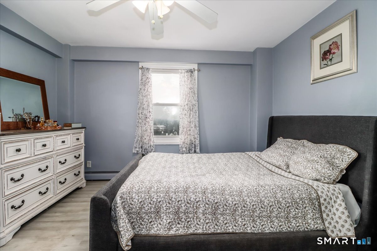 30 Glenbrook Road, Unit 10F Stamford, CT 06902 - Photo 15 of 30 a bedroom with a bed and a dresser in it