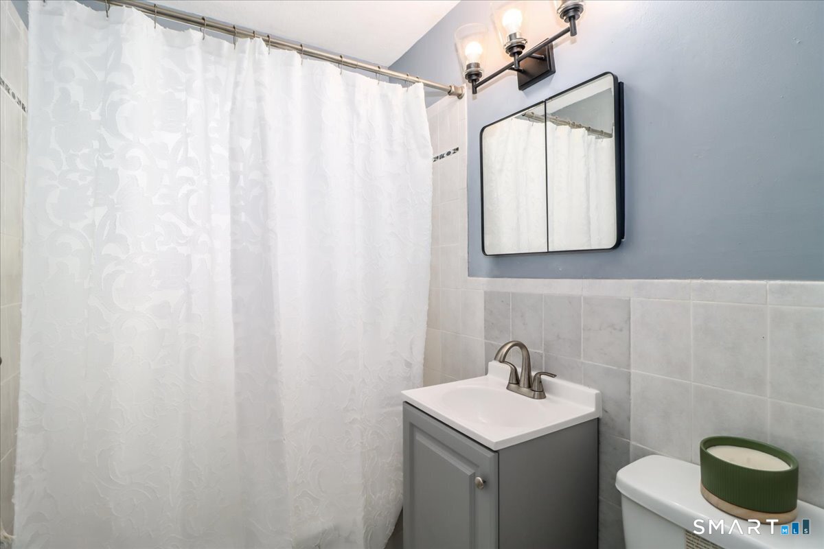 30 Glenbrook Road, Unit 10F Stamford, CT 06902 - Photo 16 of 30 a bathroom with a sink a toilet and a mirror