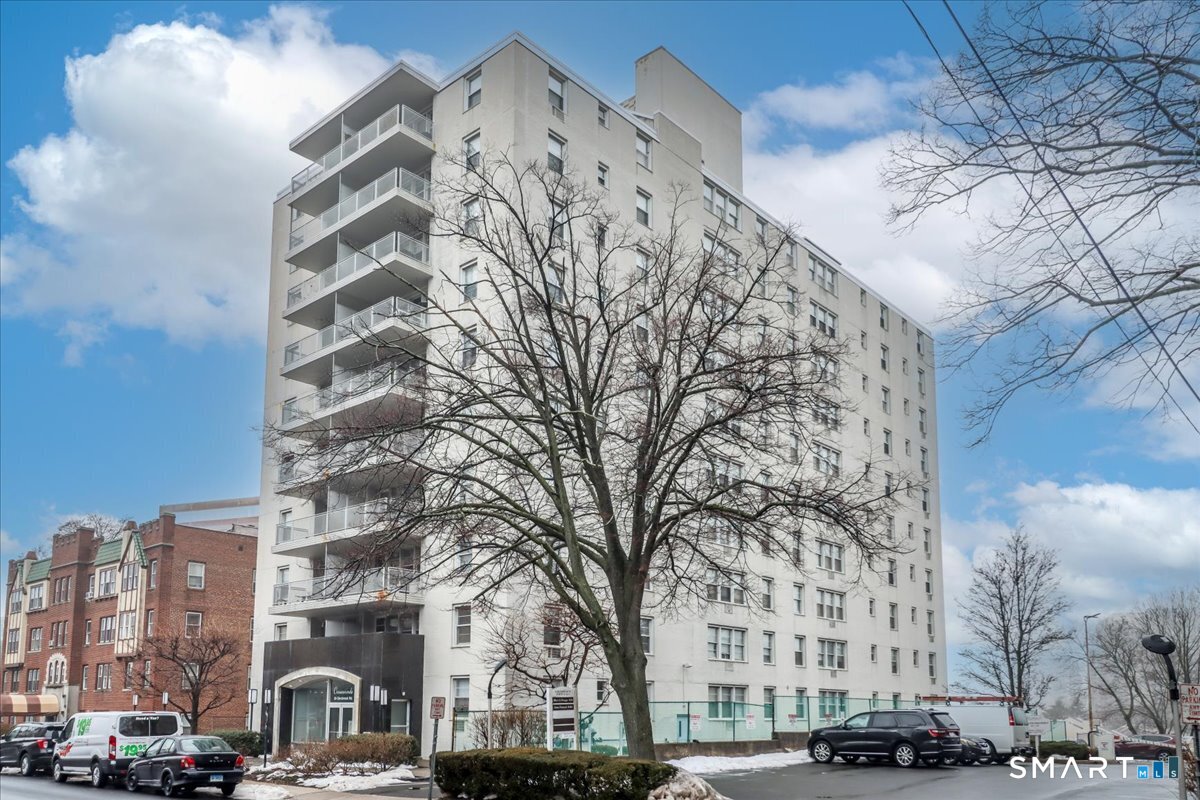 30 Glenbrook Road, Unit 10F Stamford, CT 06902 - Photo 26 of 30 a front view of a building with large trees