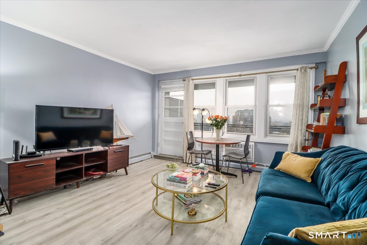 30 Glenbrook Road, Unit 10F Stamford, CT 06902 - Photo 3 of 30 a living room with furniture and a flat screen tv