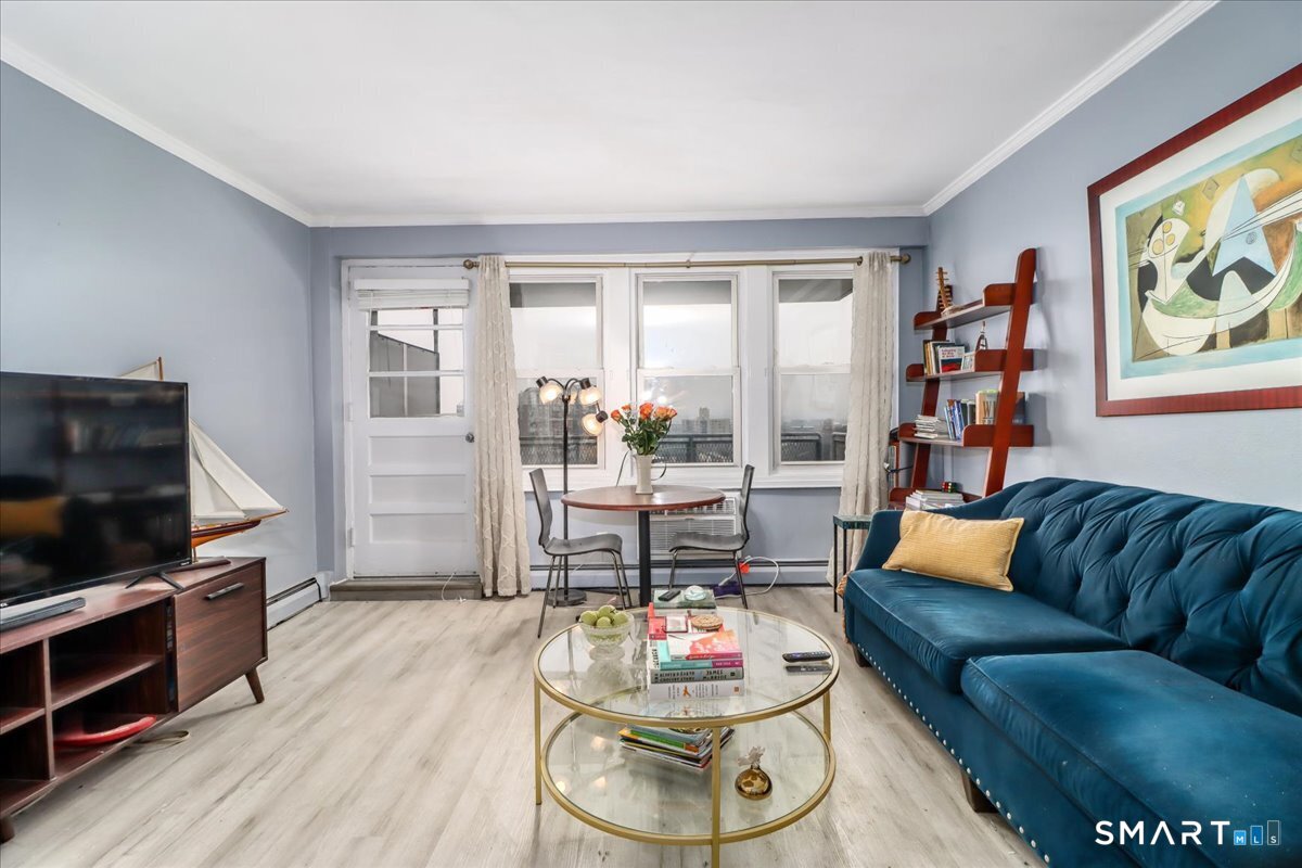 30 Glenbrook Road, Unit 10F Stamford, CT 06902 - Photo 4 of 30 a living room with furniture and a flat screen tv