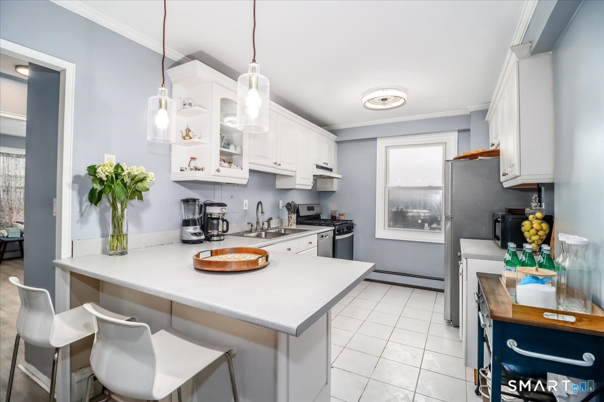 30 Glenbrook Road, Unit 10F Stamford, CT 06902 - Photo 8 of 30 a kitchen with a sink a stove and white cabinets