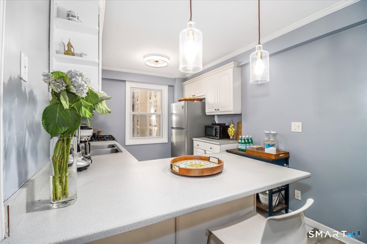 30 Glenbrook Road, Unit 10F Stamford, CT 06902 - Photo 10 of 30 a dining room with furniture and a chandelier