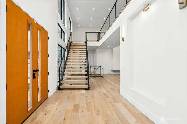 an empty room with wooden floor and entrance