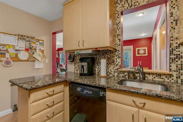 a kitchen with granite countertop stainless steel appliances sink and microwave