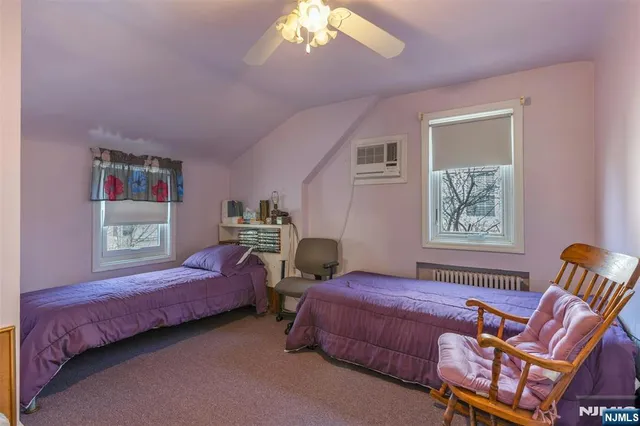 a spacious bedroom with a bed and wooden floor