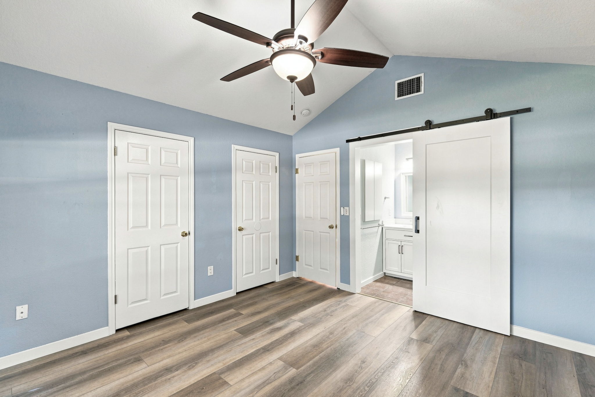 196 Prairie Springs Loop Georgetown, TX 78626 - Photo 18 of 34 Vaulted ceilings and wood-look flooring enhance this light-filled room with an adjacent private bath.