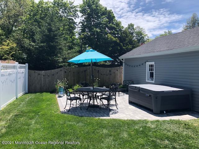 72 Rumson Road Little Silver, NJ 07739 - Photo 22 of 27 a view of a backyard with table and chairs under an umbrella