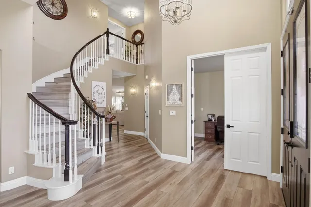 a view of a hallway with wooden floor and a chandelier