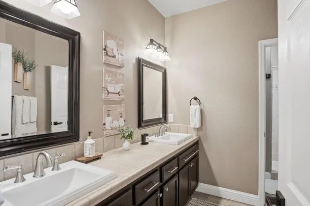 a bathroom with a double vanity sink and a mirror