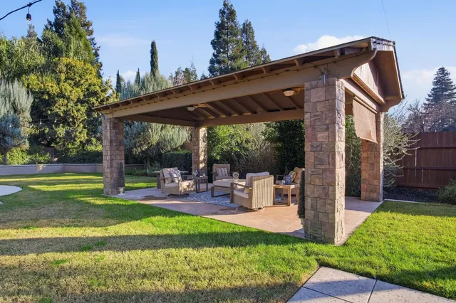 a view of a house with backyard and sitting area
