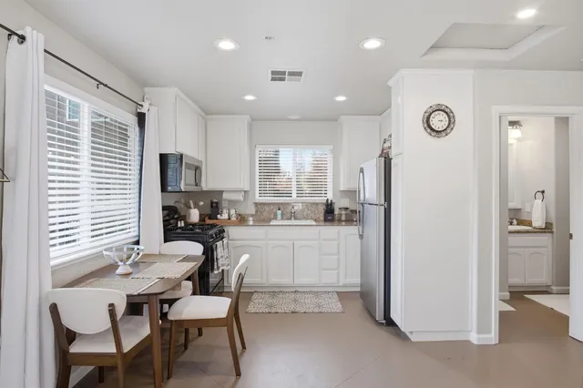 a kitchen with granite countertop a stove a sink and a microwave