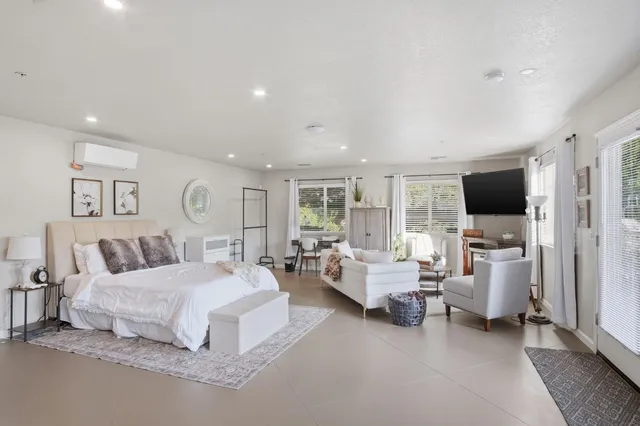 a bedroom with furniture and a large window