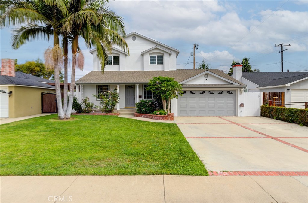 a front view of a house with a garden and palm trees