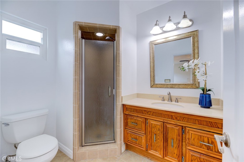 3816 Chatwin Avenue Long Beach, CA 90808 - Photo 16 of 60 a bathroom with a toilet a sink a vanity a mirror and shower