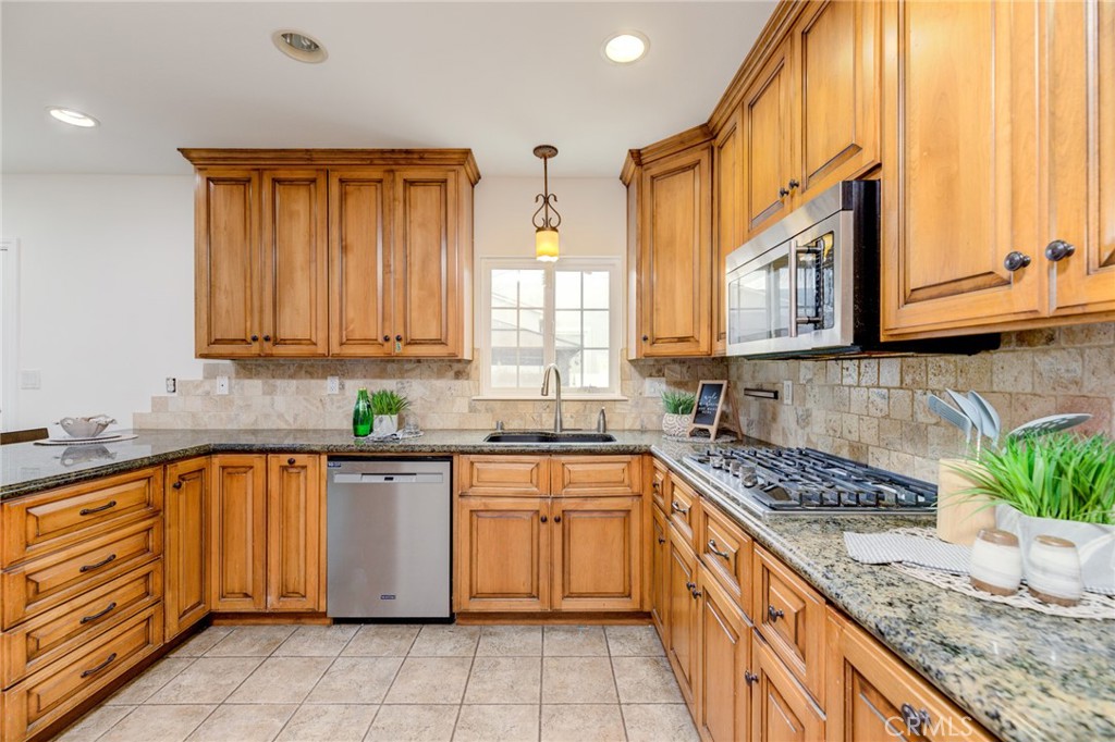 3816 Chatwin Avenue Long Beach, CA 90808 - Photo 19 of 60 a kitchen with stainless steel appliances granite countertop a stove a sink and a microwave