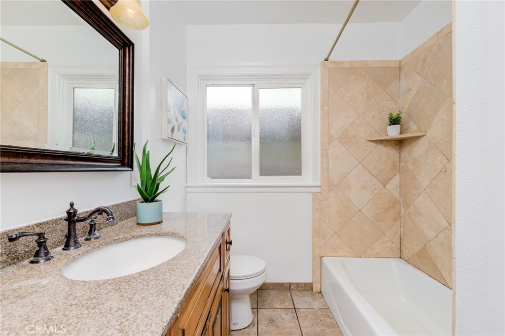 3816 Chatwin Avenue Long Beach, CA 90808 - Photo 8 of 60 a bathroom with a granite countertop sink and a mirror