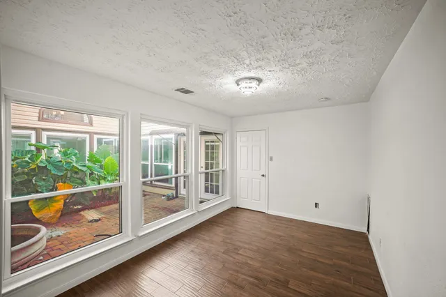 an empty room with wooden floor and glass door