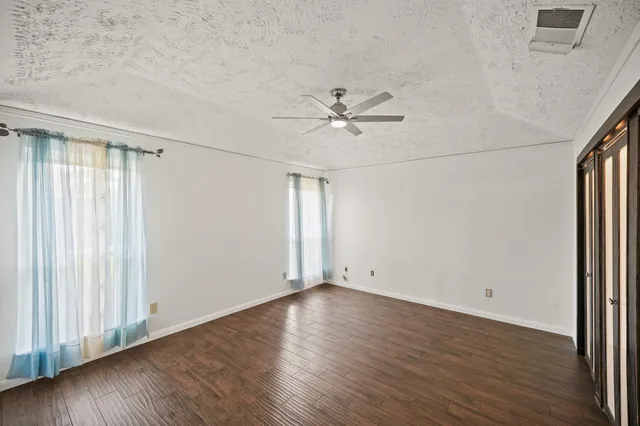 an empty room with wooden floor and window
