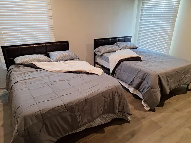 a bedroom with two beds and a night stand